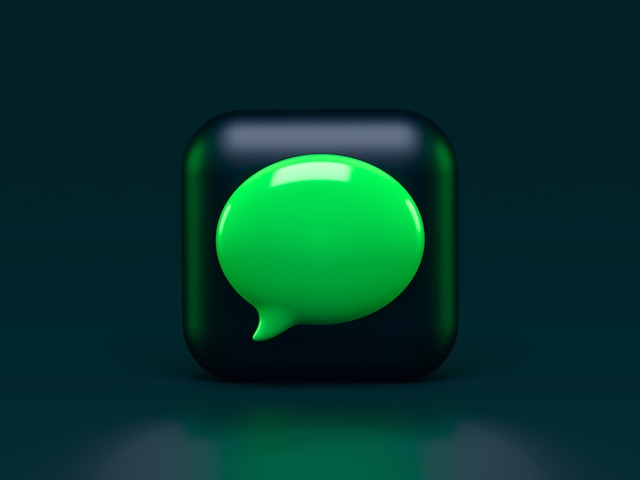 A green chat bubble inside a black cube. 
