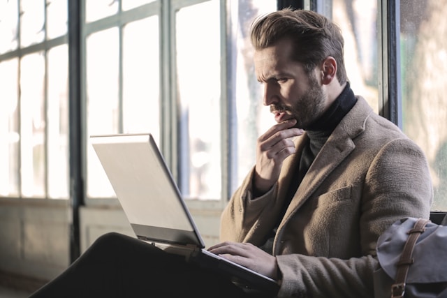 A man has his hand on his chin and looks confused as he browses on TikTok.