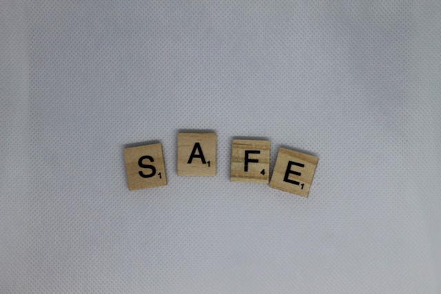 Wooden Scrabble tiles spell the word “SAFE.”