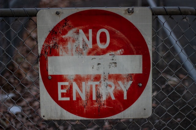 A faded, red, and white No Entry sign.
