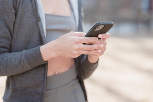 A person uses a phone outside.
