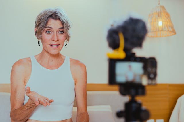 An older woman animatedly speaks into a camera.