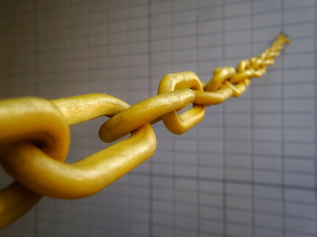 A yellow chain blocks entry into a building.