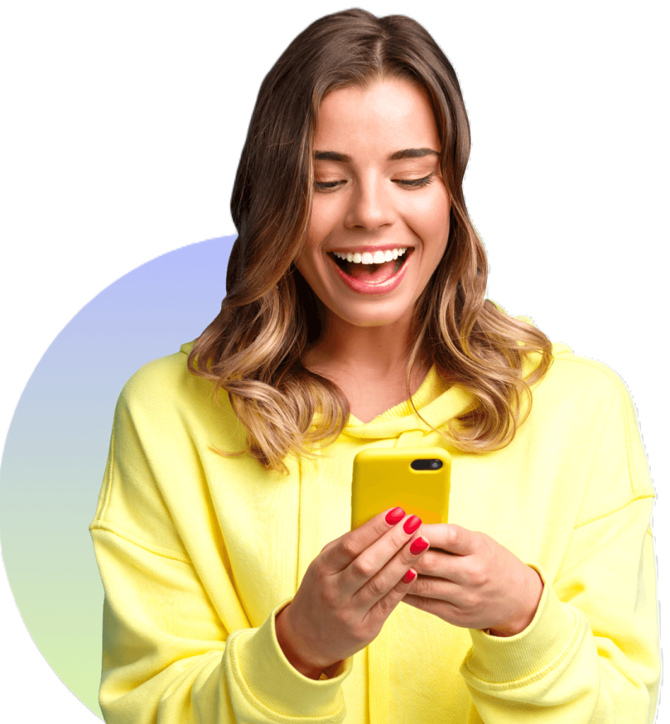 A woman wears a big smile as she looks at her phone.