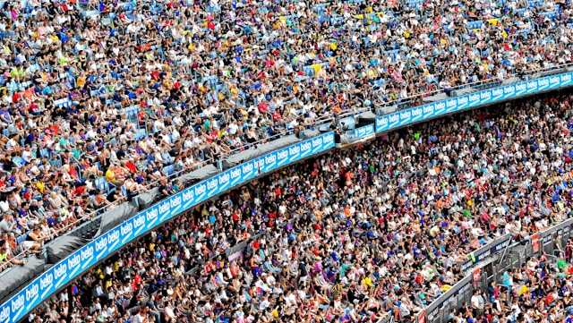 A massive audience fills up the seats of a big outdoor stadium.