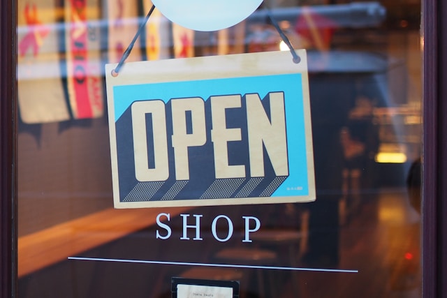 A sign on a door indicates that a shop is open.
