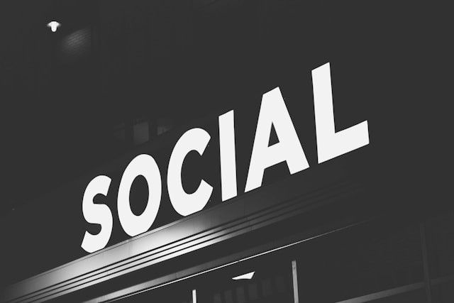 A bright sign reads “Social” at night.
