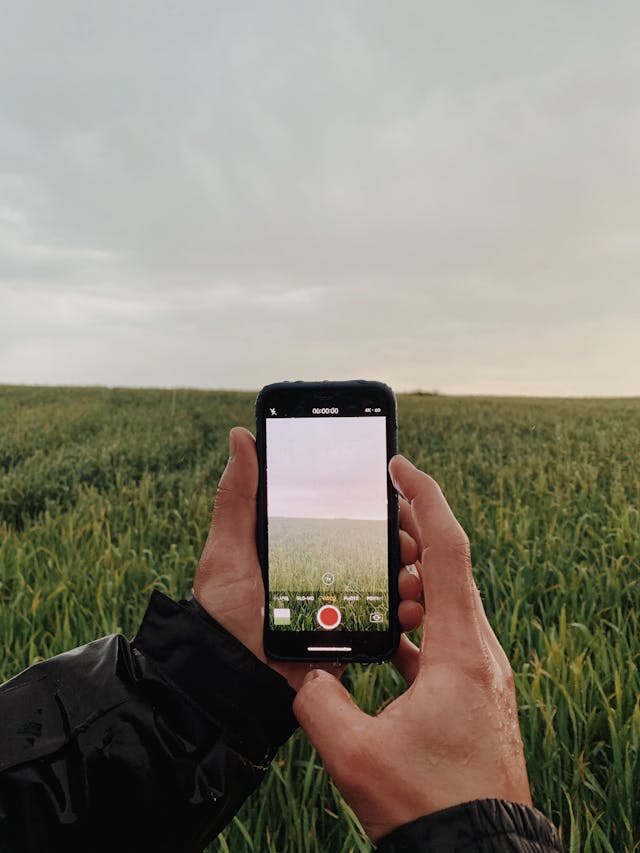 A person records the scenery of the outdoors.
