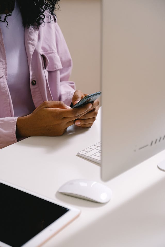 A woman's hands type on a cell phone.