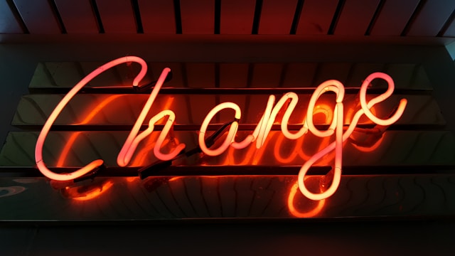 A red neon sign reads, “Change.”
