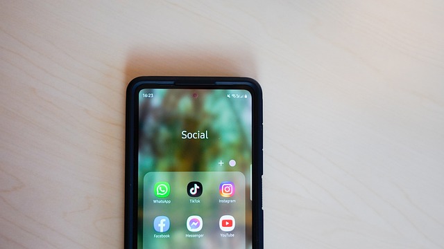 A phone displays a social media apps folder containing TikTok and other apps.
