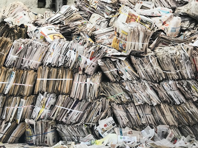 Tied-up newspapers stacked on top of each other. 
