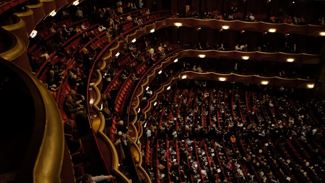 Viewers fill up the tiered seats in a theater. 
