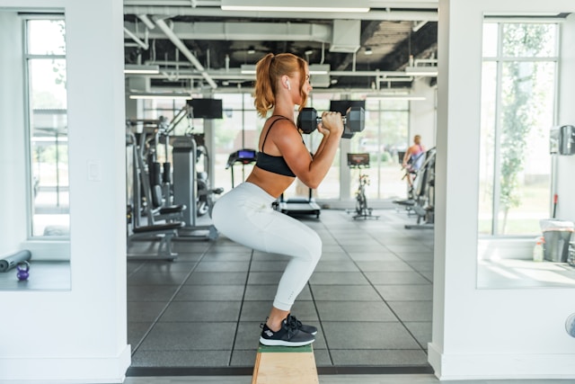 A woman performs dumbbell workouts for a TikTok video. 
