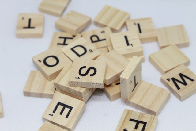 A small pile of wooden Scrabble tiles on a table.