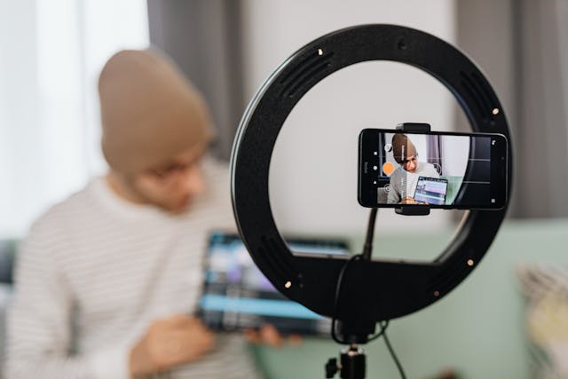 A man with a tablet records a video.
