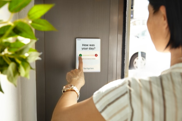 A person answers the question, “How are you feeling today?” displayed on a digital screen. 
