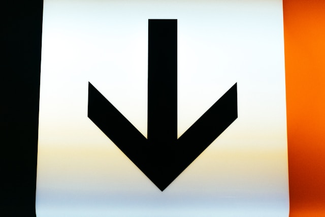 A black arrow pointing down on a white background. 
