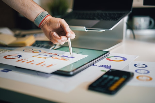 A person studies printouts of graphs. 
