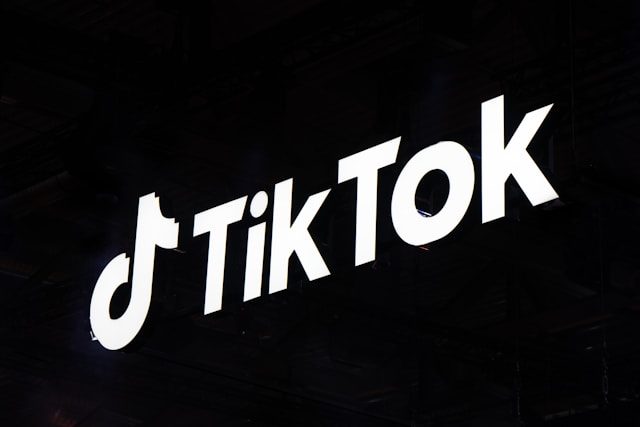 A white design of the TikTok logo on a black background.
