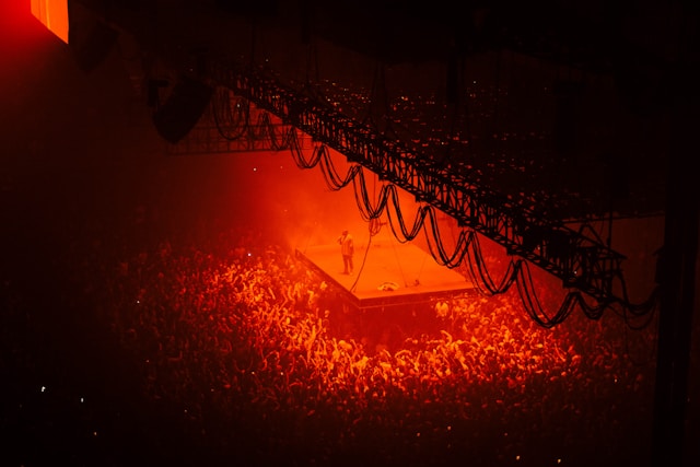 A singer performs on a stage in front of a massive audience. 
