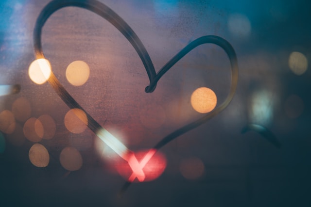  A glass window shows a finger-traced heart shape. 