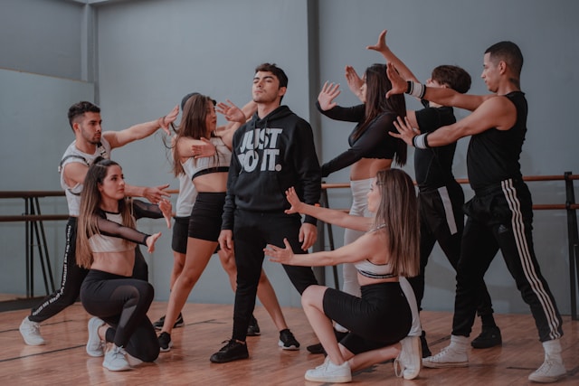 A group of dancers practices in a dance studio. 
