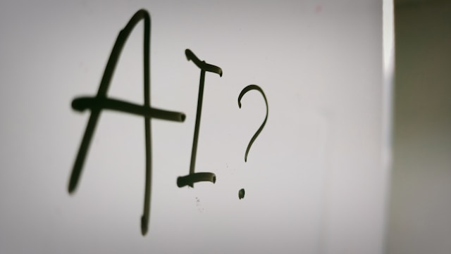 A whiteboard with the word “AI” and a question mark printed on it. 