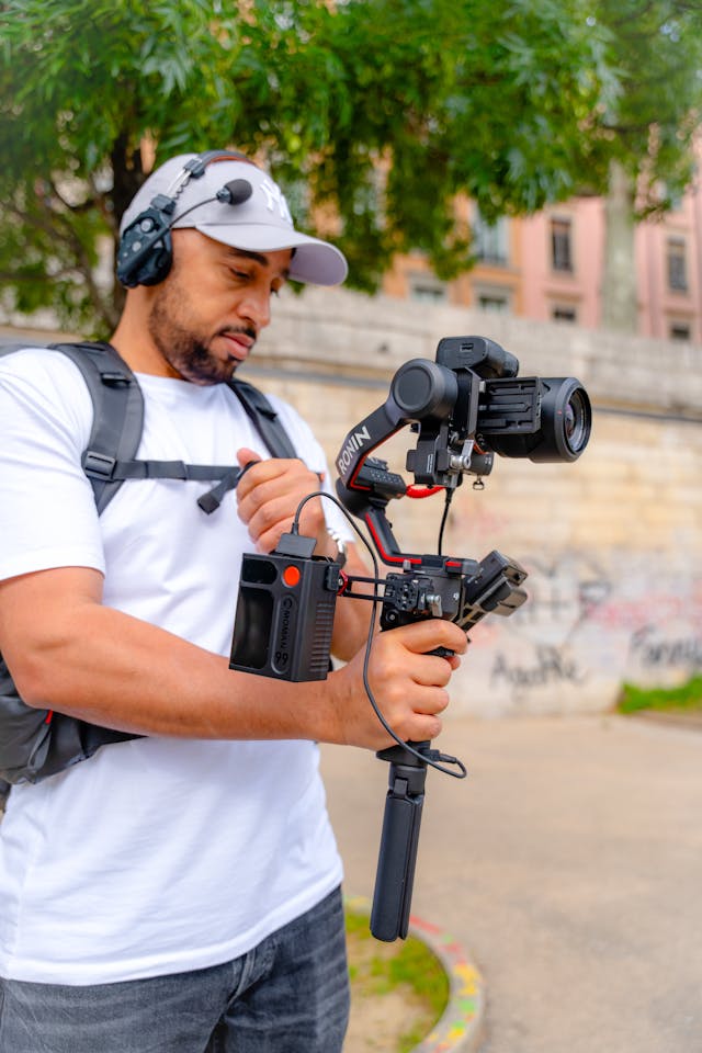 A man records something with a very large camera.
