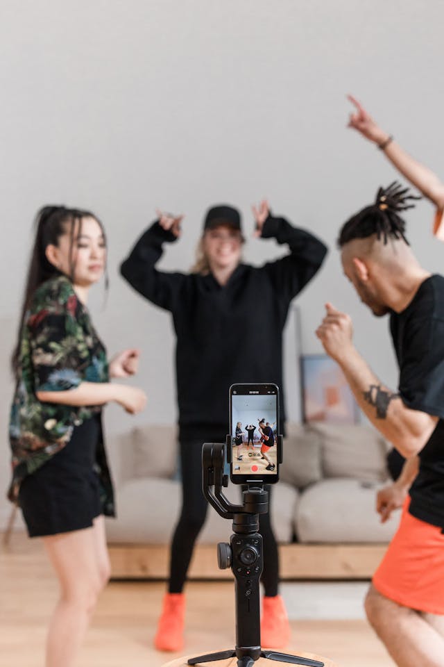 Three friends record a TikTok dance video.
