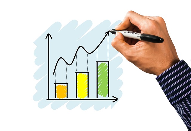 A person draws an upward graph on a whiteboard.
