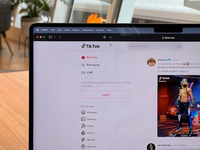 A laptop screen displays a random TikTok For You feed. 
