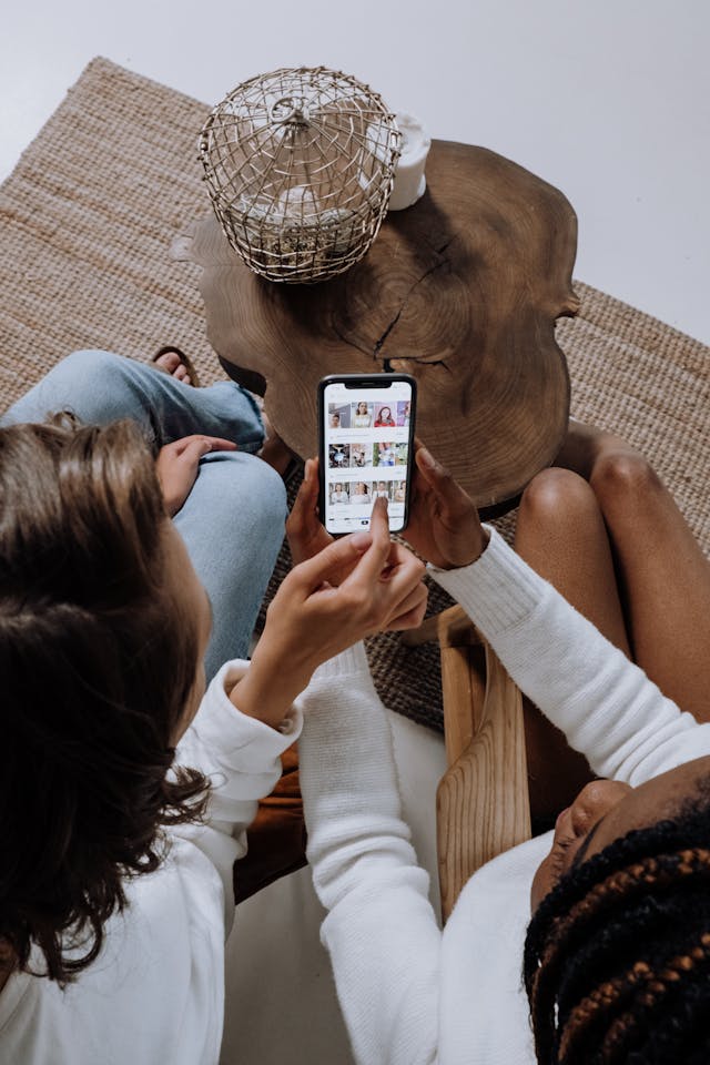 Two women scroll through videos.
