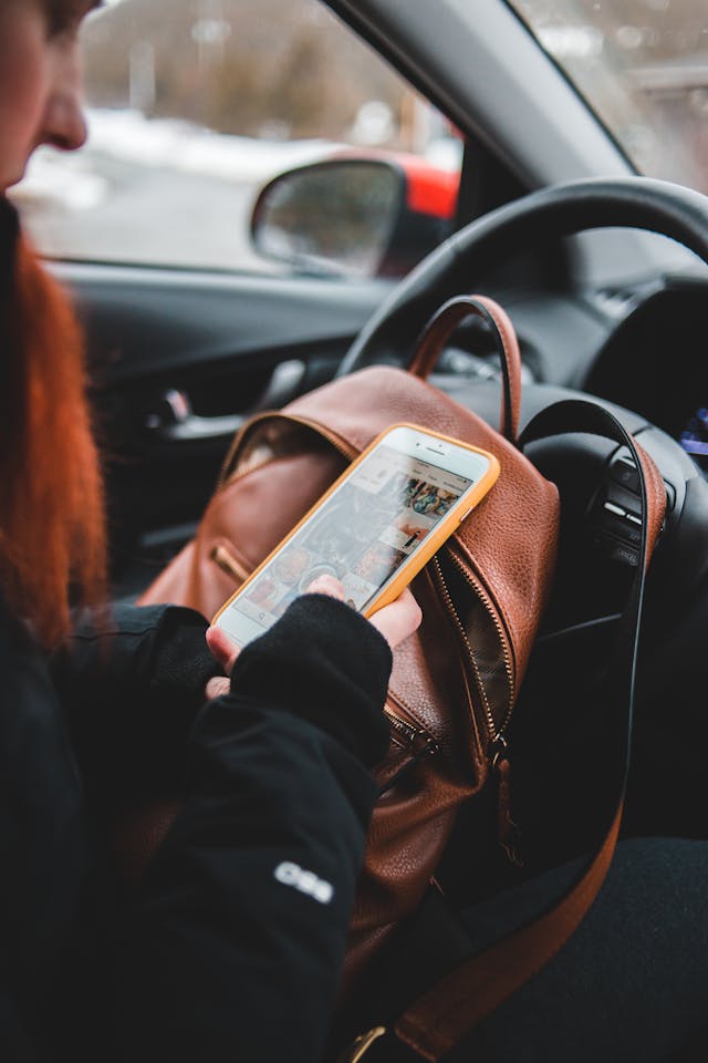 A person uses their phone in a car.