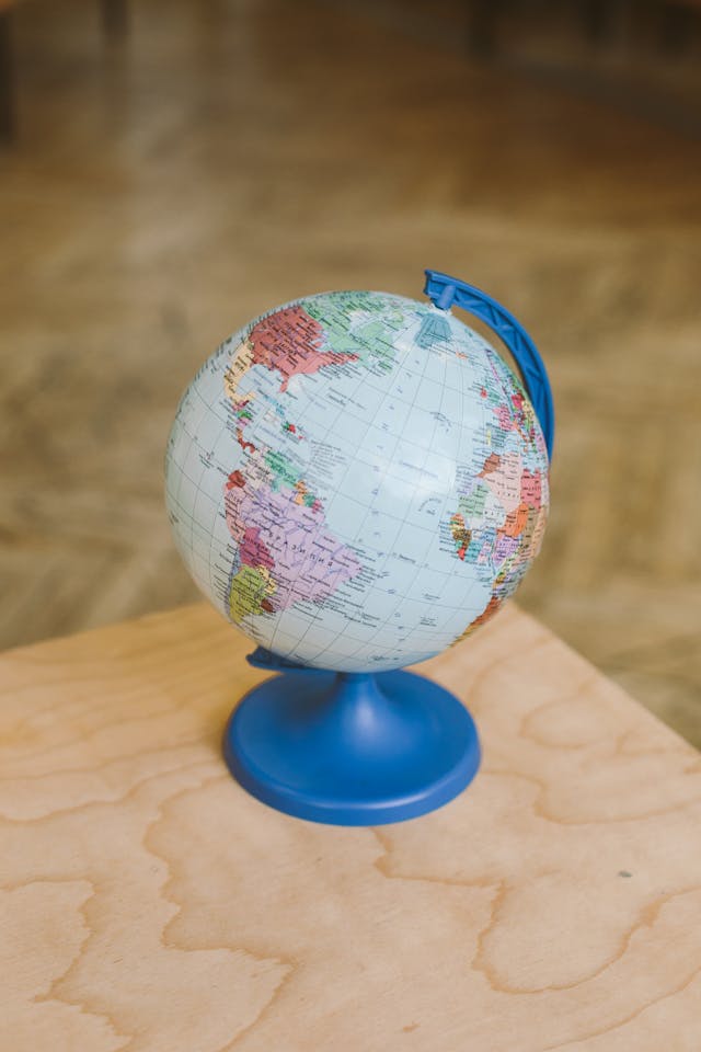 A globe rests on top of a wooden surface.