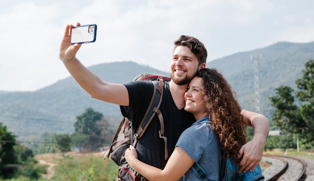 A couple takes a photo while they travel.
