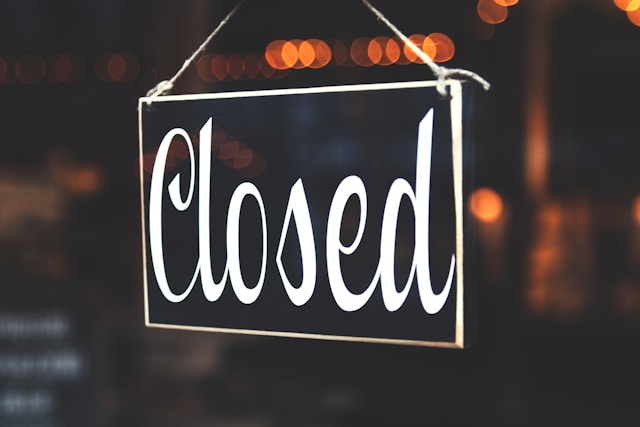 A closed sign hangs in a store window. 
