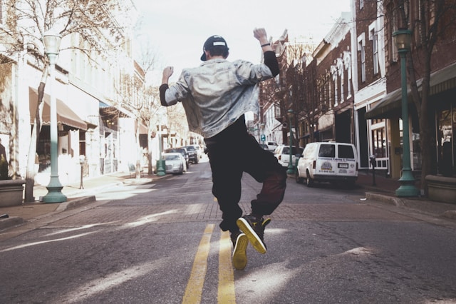 A man dances in the middle of an empty street. 

