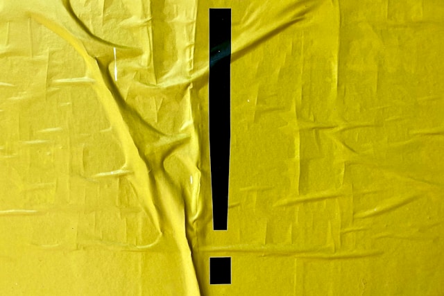 A black exclamation mark on yellow fabric. 