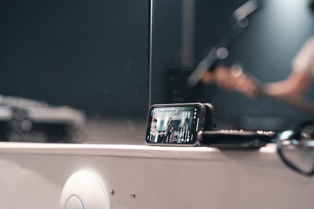 A smartphone leans against a mirror and captures a band’s live performance for a TikTok audience.