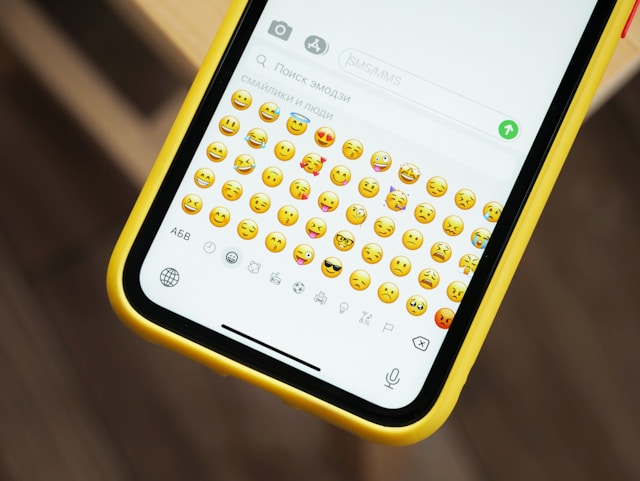 A phone screen shows a messaging app’s emoji keyboard. 
