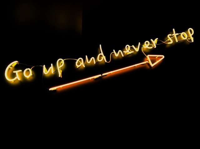 A neon sign that says, “Go up and never stop.” 
