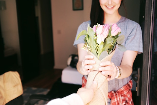 A woman receives a bouquet of flowers. 