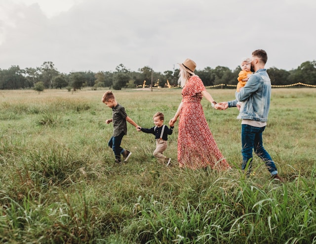 Una famiglia di cinque persone in un grande campo vuoto.