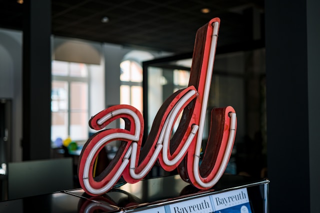 A red and white sign on top of a stainless steel shelf says, “Ad.”
