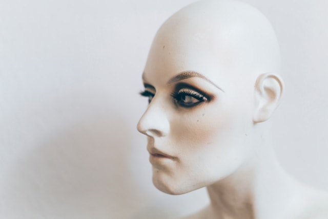 A white mannequin’s head with lifelike facial features. 
