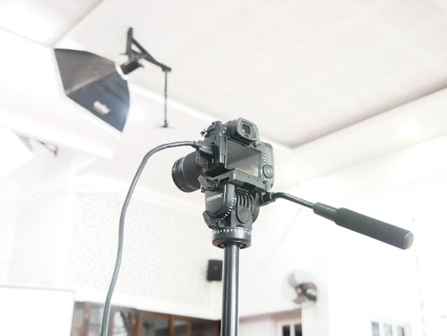 A DSLR camera on a tripod and professional lighting equipment. 
