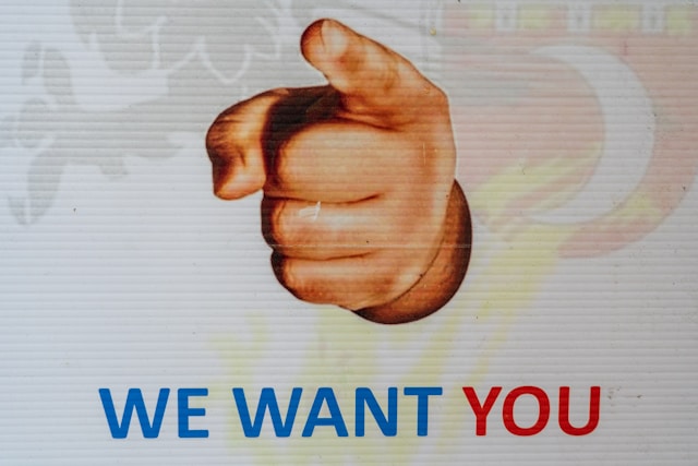 A sign with a pointing hand and the words, “We want you.”
