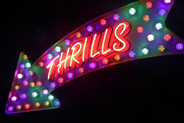 A curved arrow sign with multi-colored bulbs.
