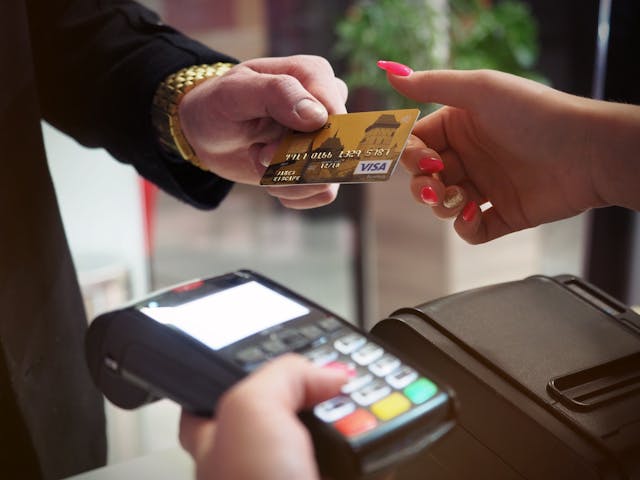 A person uses a VISA card to make a payment.